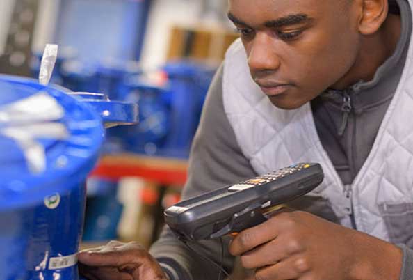 a young black man scan a code on the side of a blue bucket